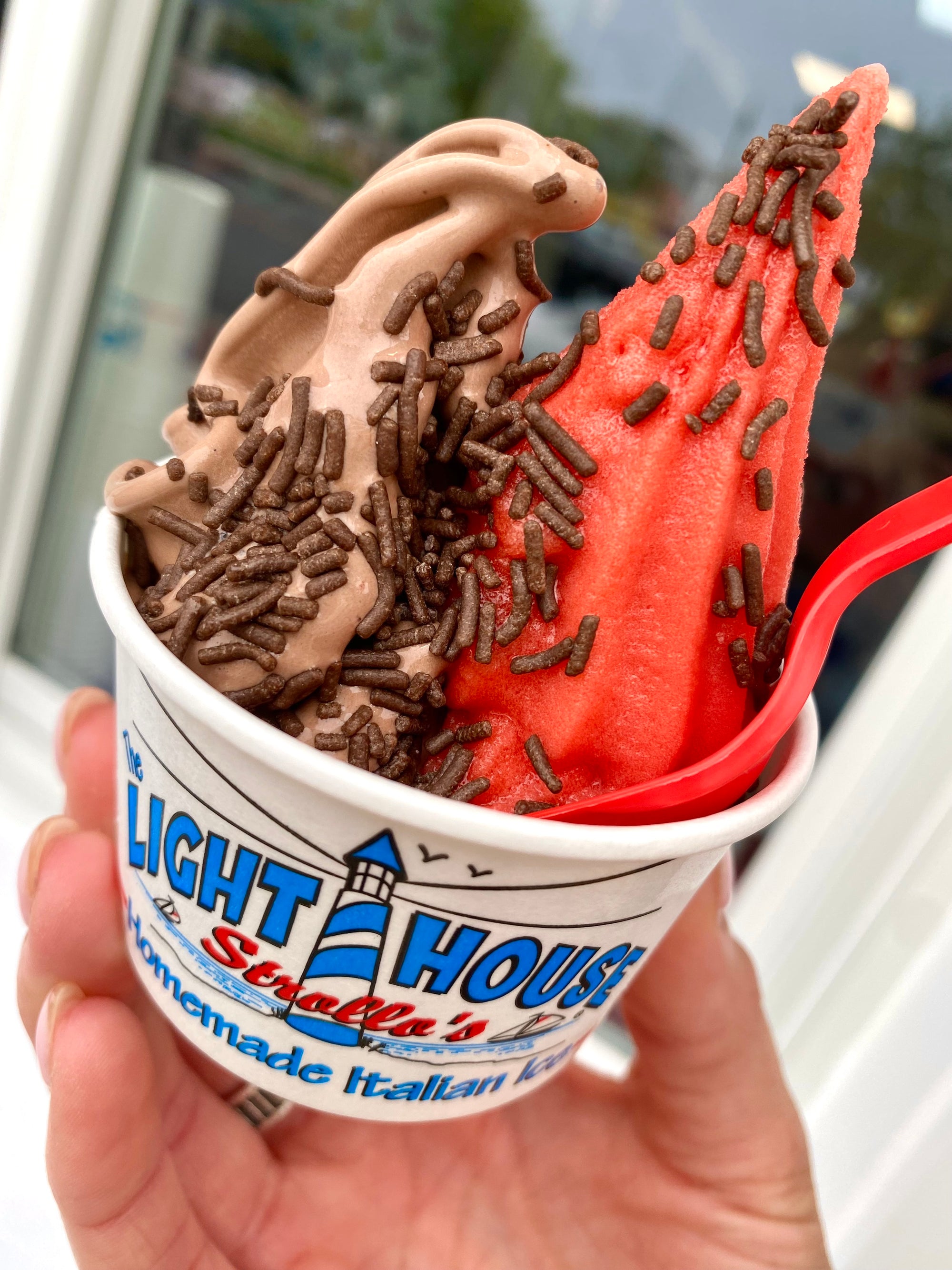 A Strollo's Lighthouse cup with chocolate soft serve and homemade cherry Italian ice topped with chocolate sprinkles
