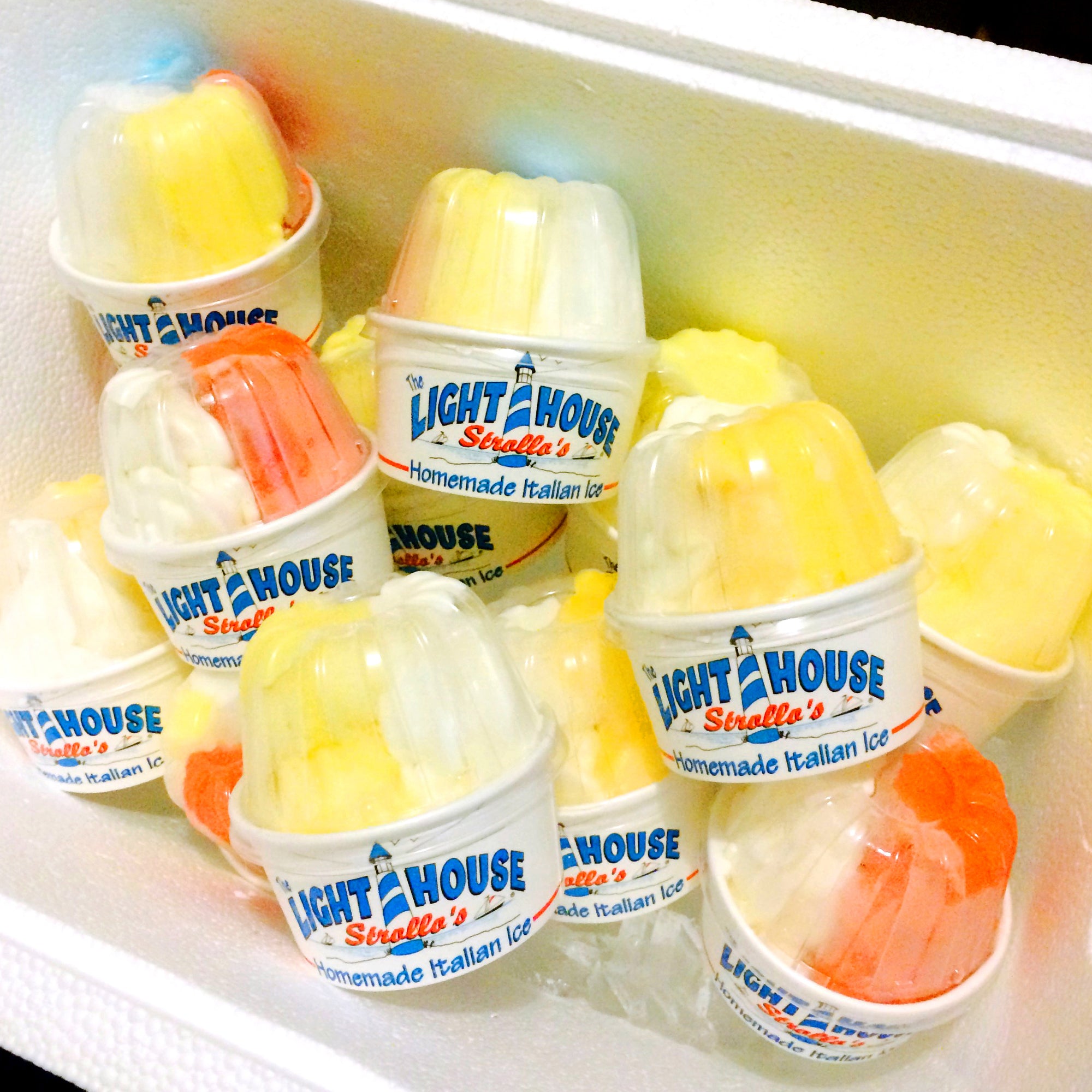 A Strollo's Lighthouse cooler full of cups of homemade Italian Ice and soft serve ice cream